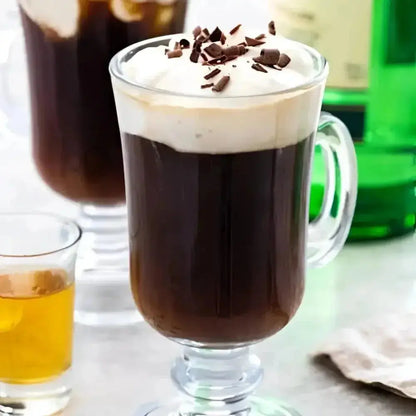 Irish coffee in a glass mug topped with cream and chocolate flakes
