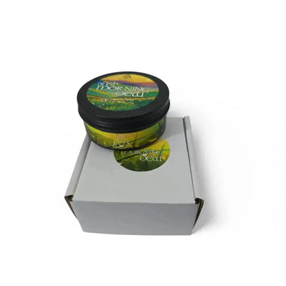 Irish Morning Dew candle tin on a grey mailer box with a round sticker