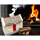White cottage burner with a brown roof and red door, smoke rising from the chimney, turf sods beside it