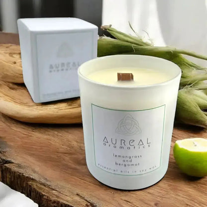 Aureal lemongrass and bergamot candle in a white glass beside its white box and a lime